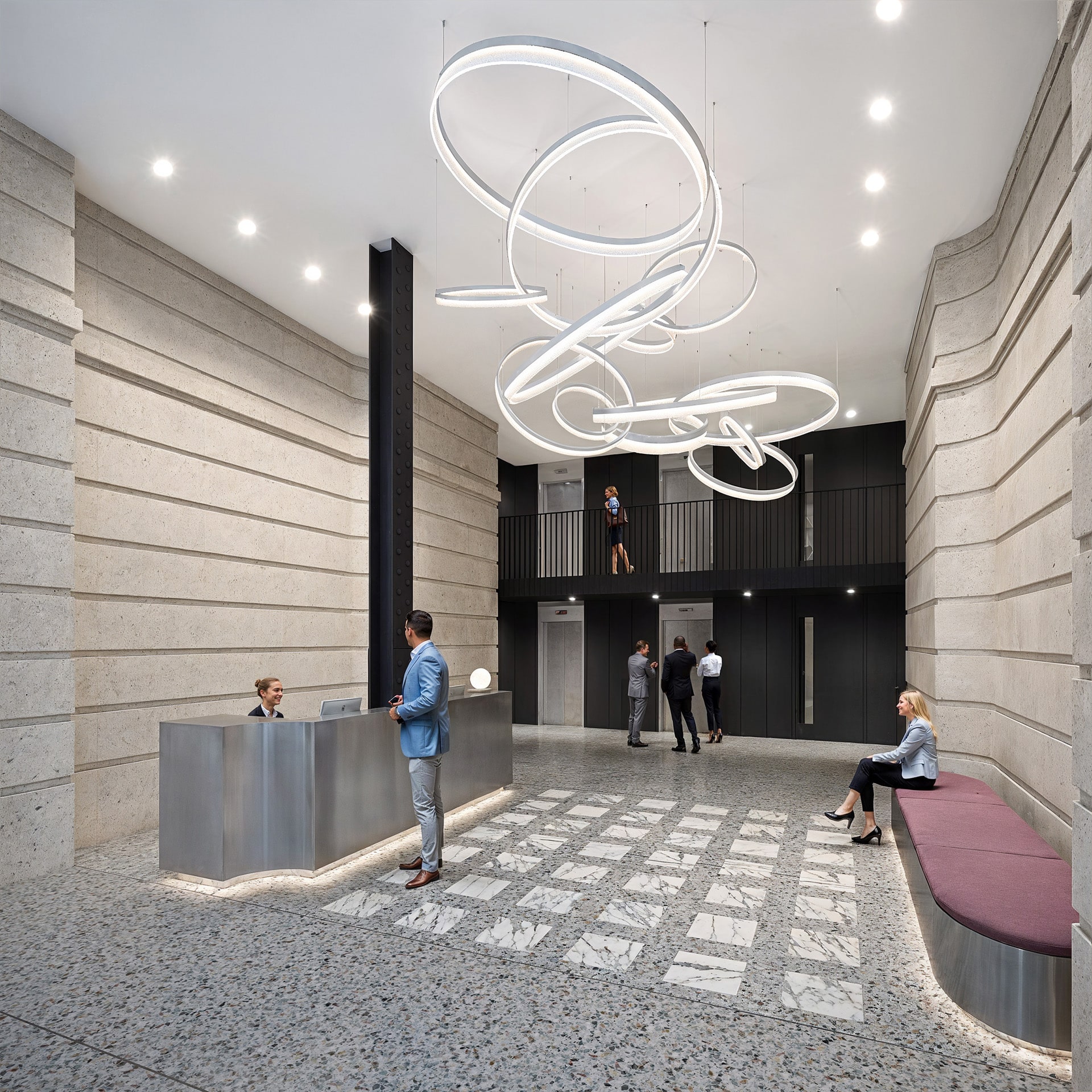 Modern lobby with artistic lighting, people at reception, and waiting area.