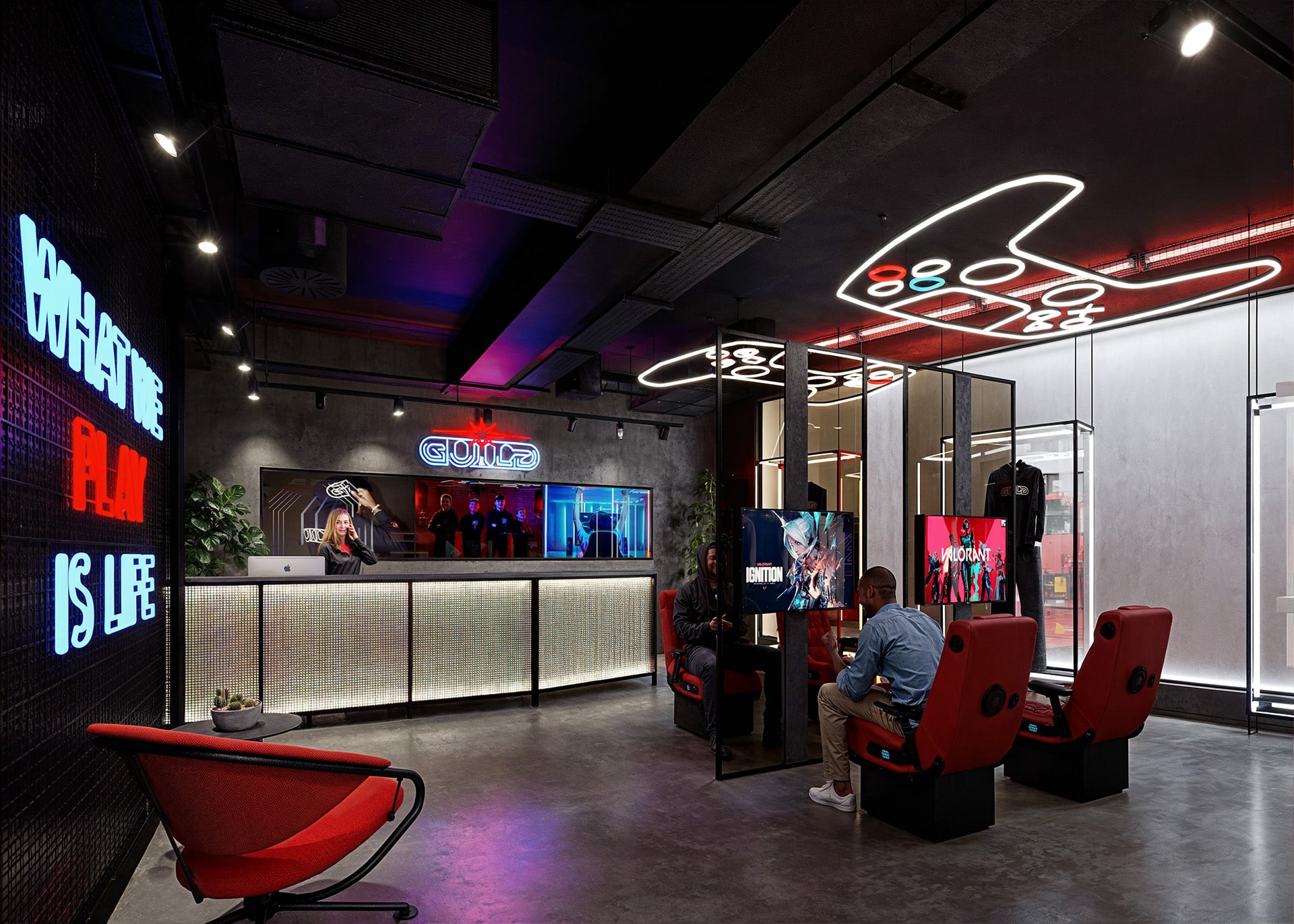 Gaming-themed lounge with neon lights, modern seating, and a large screen.