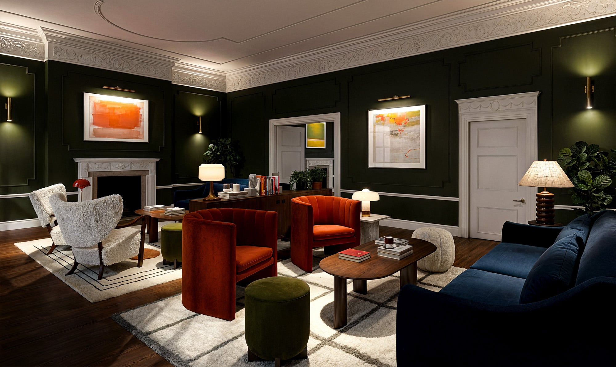 Stylish living room with dark walls, modern furniture, and warm lighting. Paintings adorn the walls.