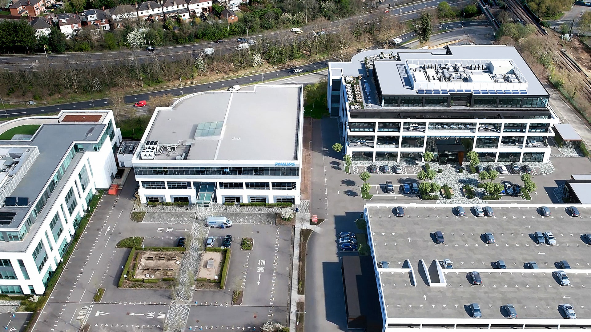 Aerial view of modern office buildings surrounded by roads and parking lots.