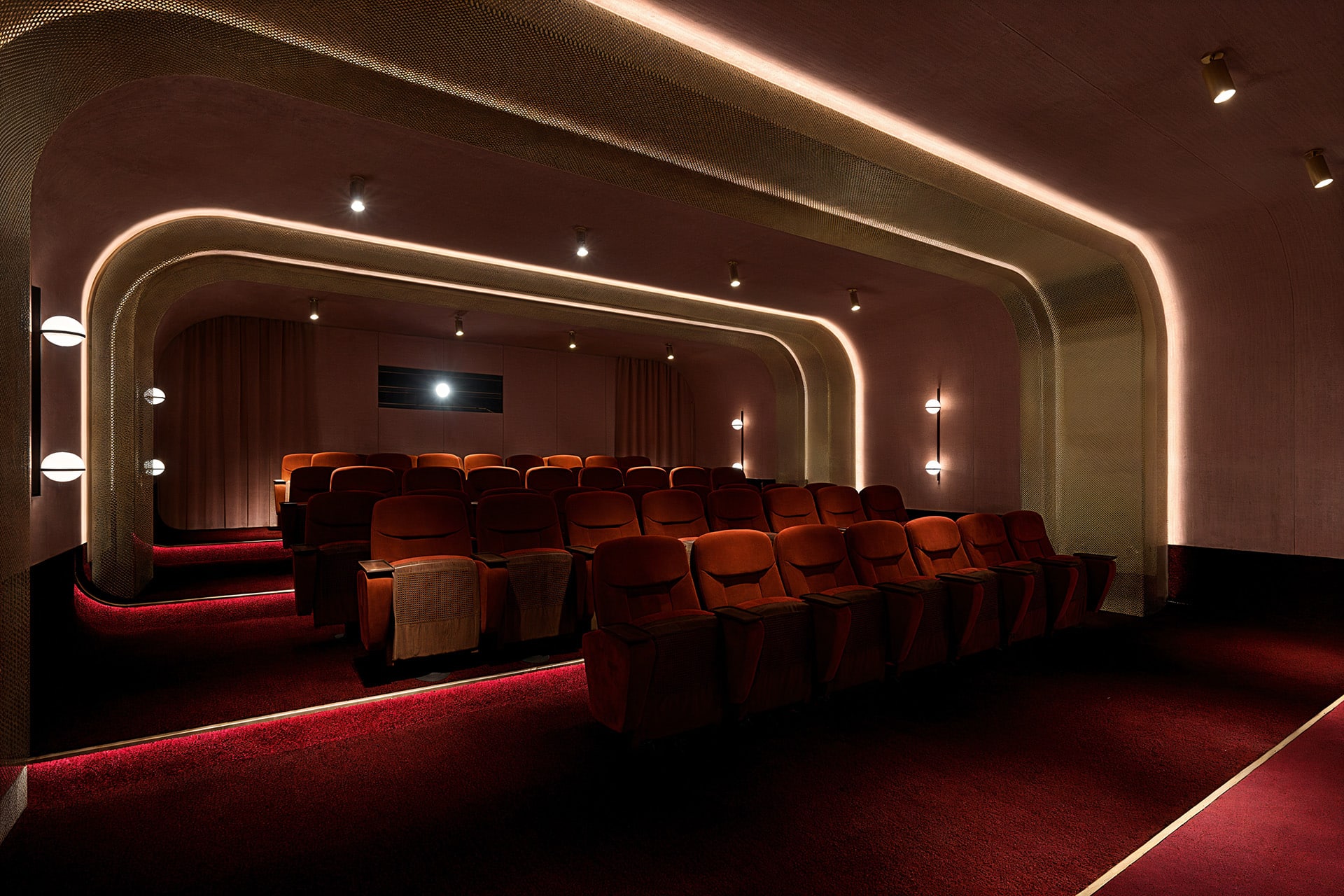 Stylish, empty cinema with plush red seats and soft ambient lighting.