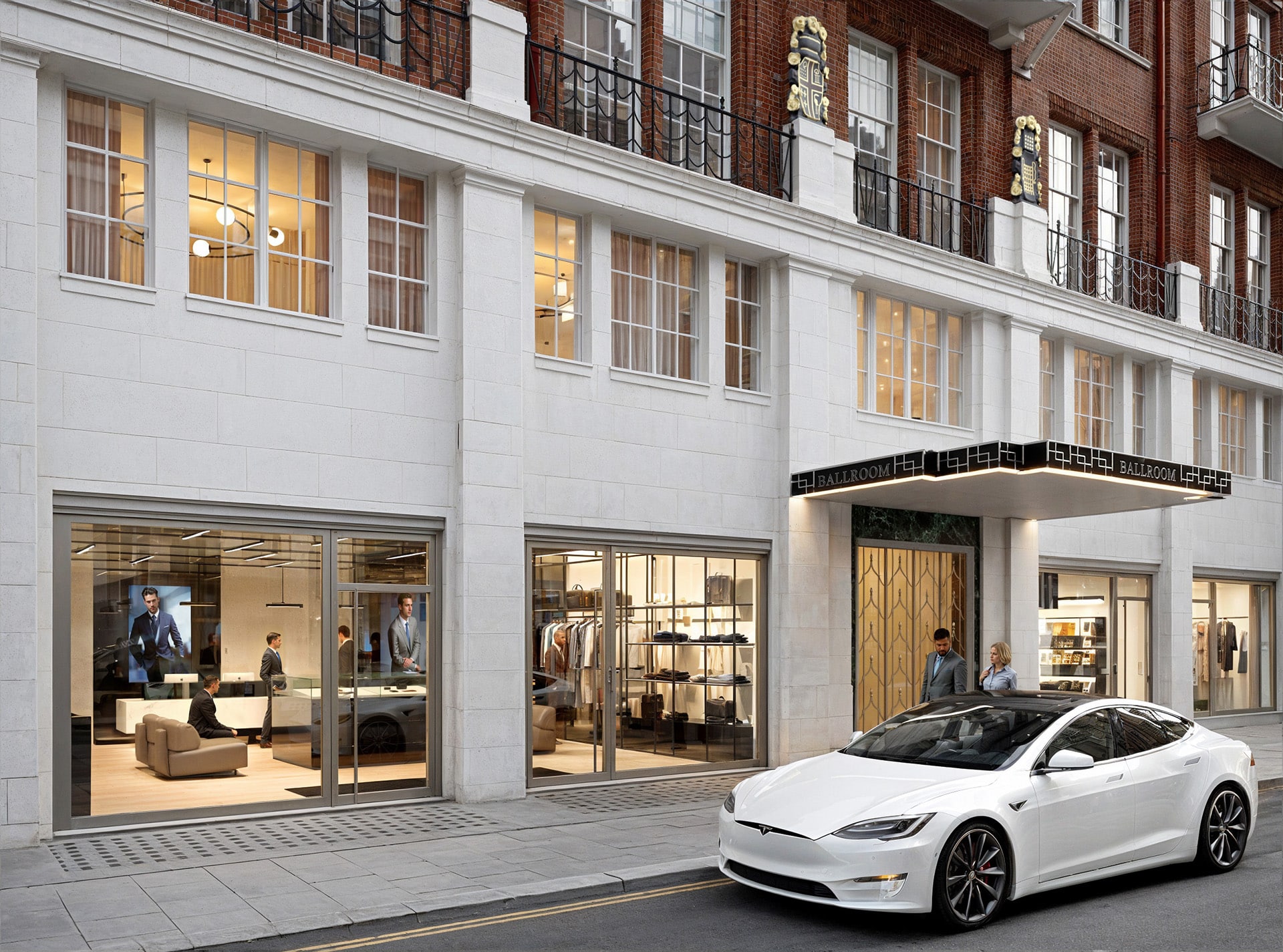 White car parked in front of a stylish, modern building with large storefront windows.